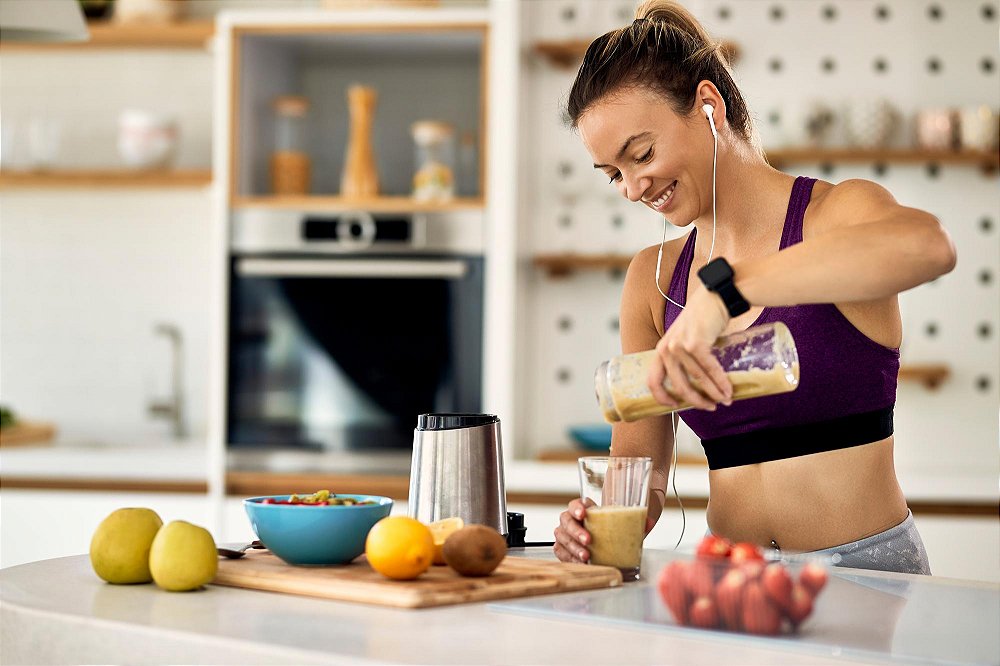 Mulher preparando receita de shake de proteína com Whey Protein Concentrado Soldiers Nutrition em uma cozinha