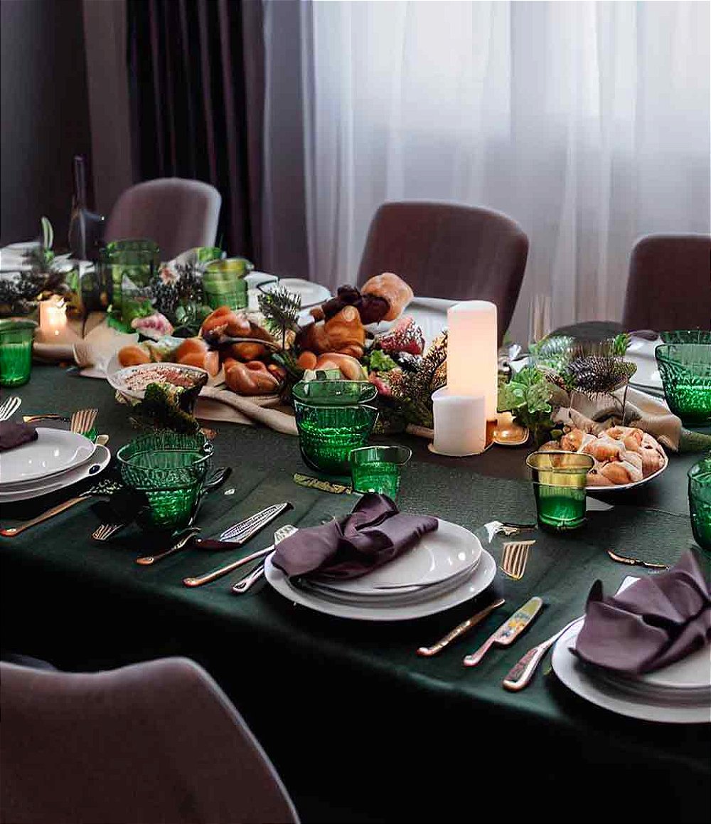 ambiente clássico com mesa grande e  toalha de mesa verde escura de linho com mesa posta e arranjos florais