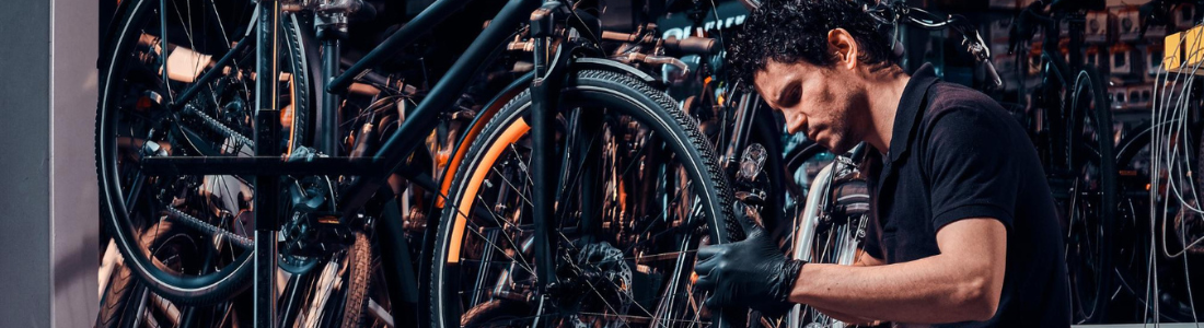 imagem mostra mecânico fazendo a manutenção de um bicicleta