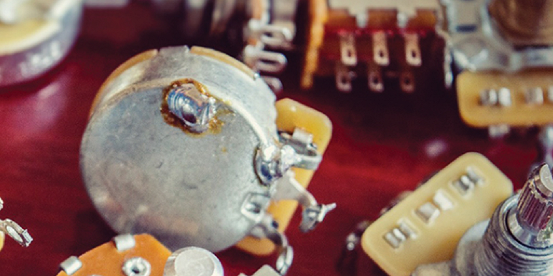 Potenciômetros e componentes de elétrica para guitarra em bancada de trabalho