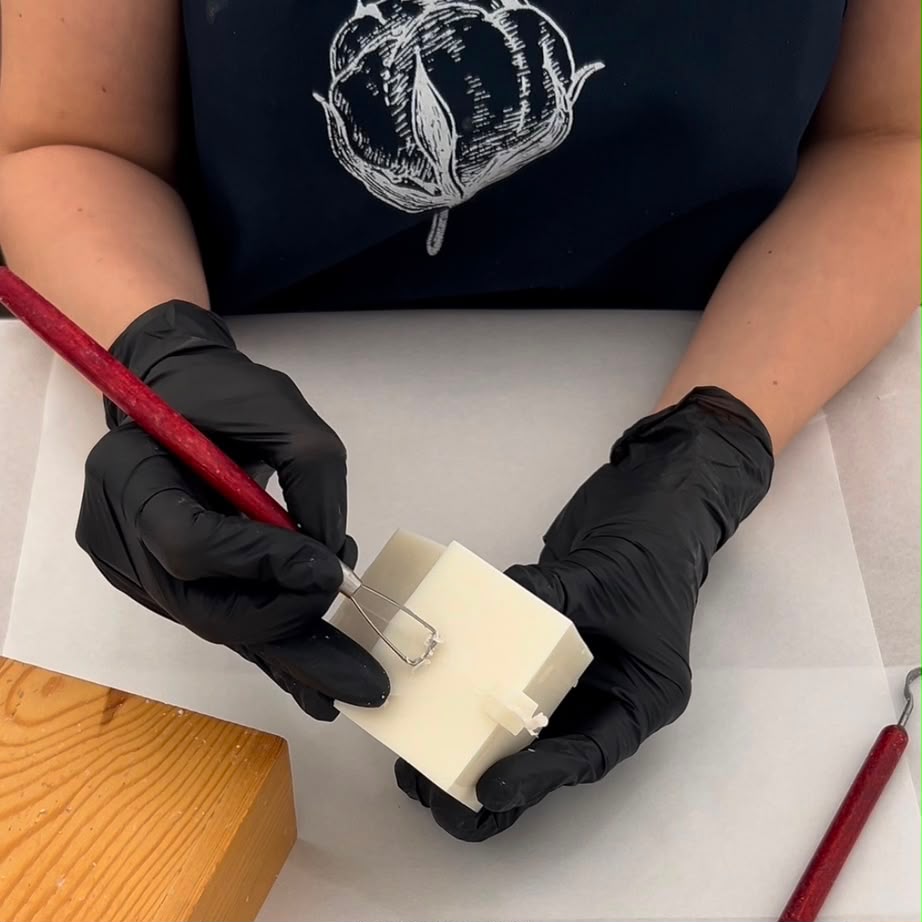 Despejando cera dourada em molde de vela artesanal