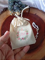 Mini terço no saquinho de algodão cru.