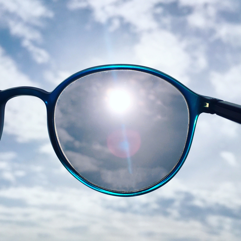 lente fotossensível em óculos redondo escurecendo ao sol
