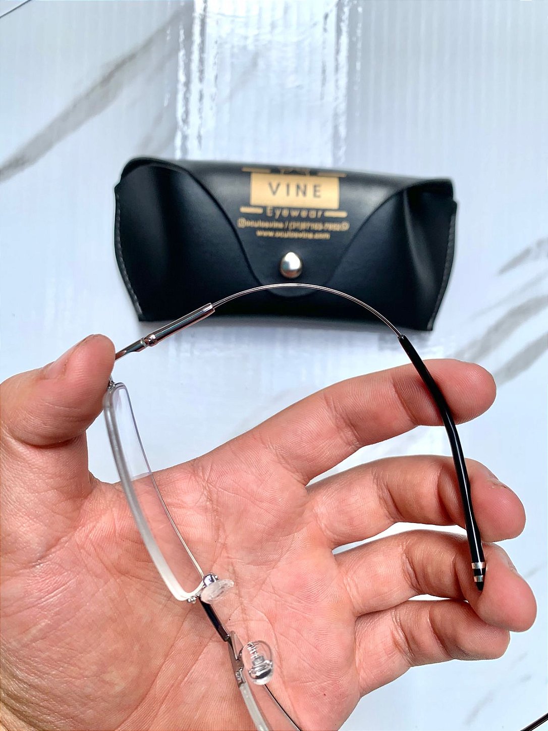 Armação de grau Titanium masculina  tendo sua haste completamente dobrada mostrando sua flexibilidade - Óculos Vine