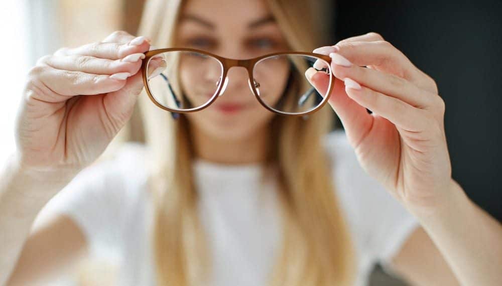 Miopia mulher segurando óculos para miopia