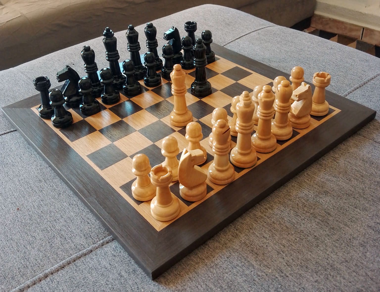 Tabuleiro de xadrez com peças brancas e pretas na mesa de madeira com  poltrona de luxo vintage. conceito de jogo de tática de estratégia