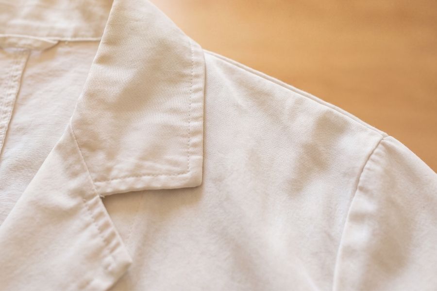 Detalhe da gola e do tecido de um jaleco branco