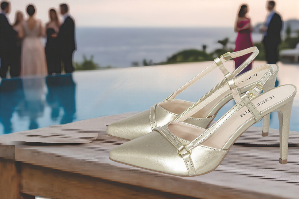 Sapato scarpin feminino modelo slingback de bico fino na cor napa Dourado-Champagne Torricella  com fivela dourada, exposto sobre uma mesa de vidro em uma galeria de arte moderna luxuosa.