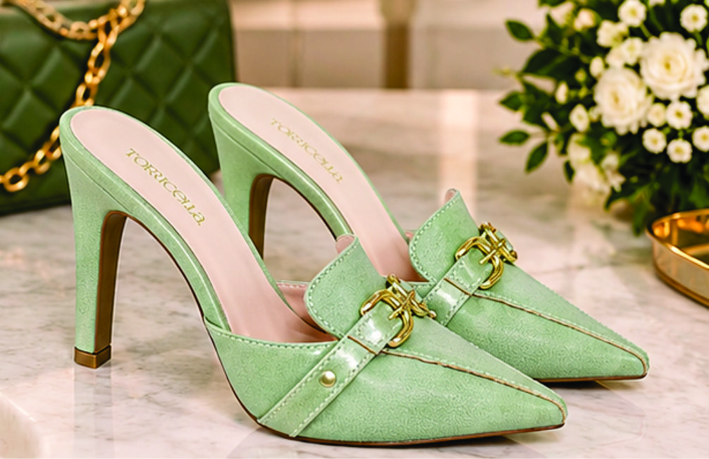 Sapato scarpin mule feminino de bico fino e salto alto revestido em napa Verde Torricella, com detalhe de fivelas douradas no cabedal na sala moderna e estilosa.06