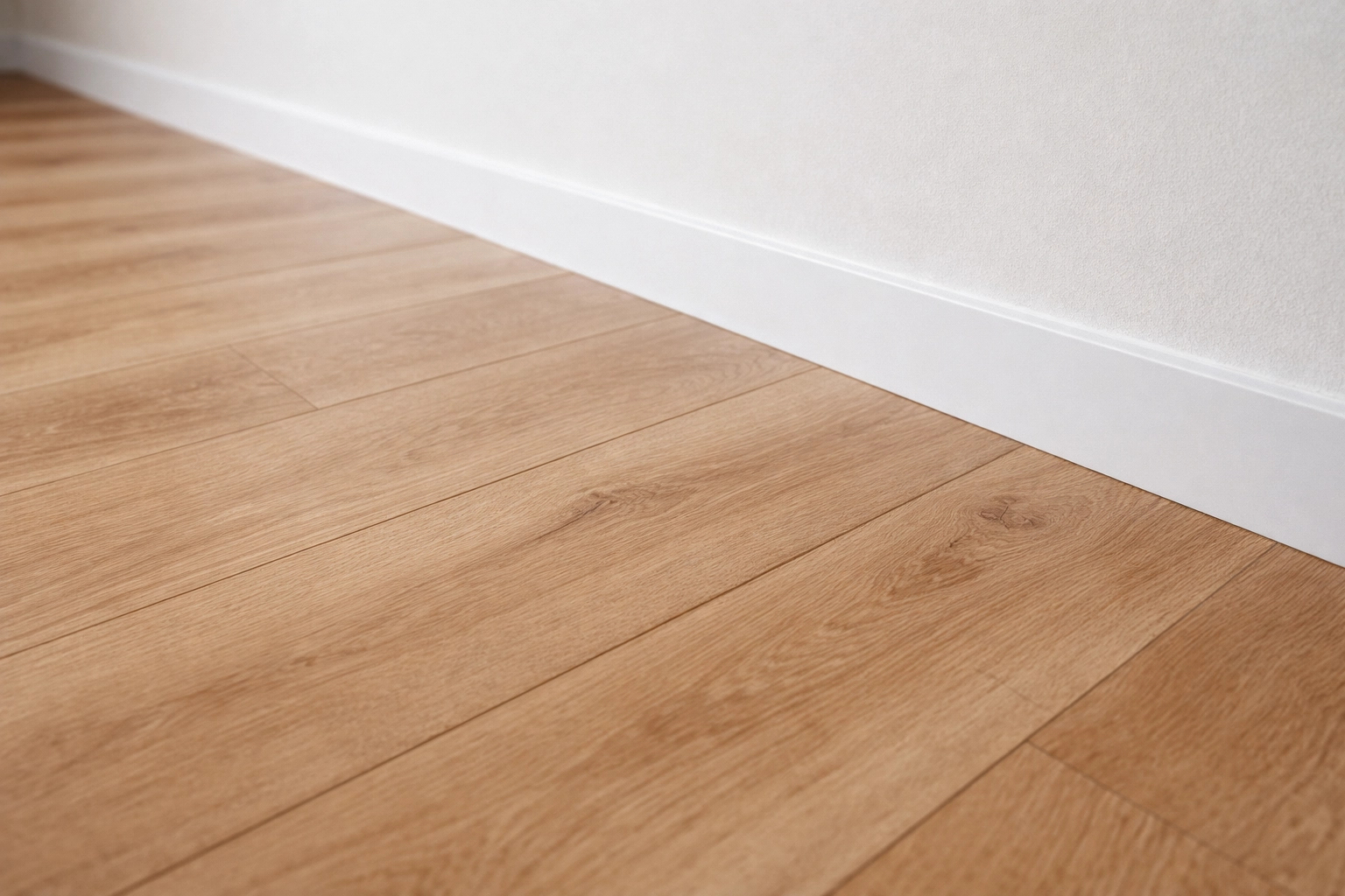 Piso laminado instalado com rodapé branco em apartamento na Zona Oeste do Rio de Janeiro