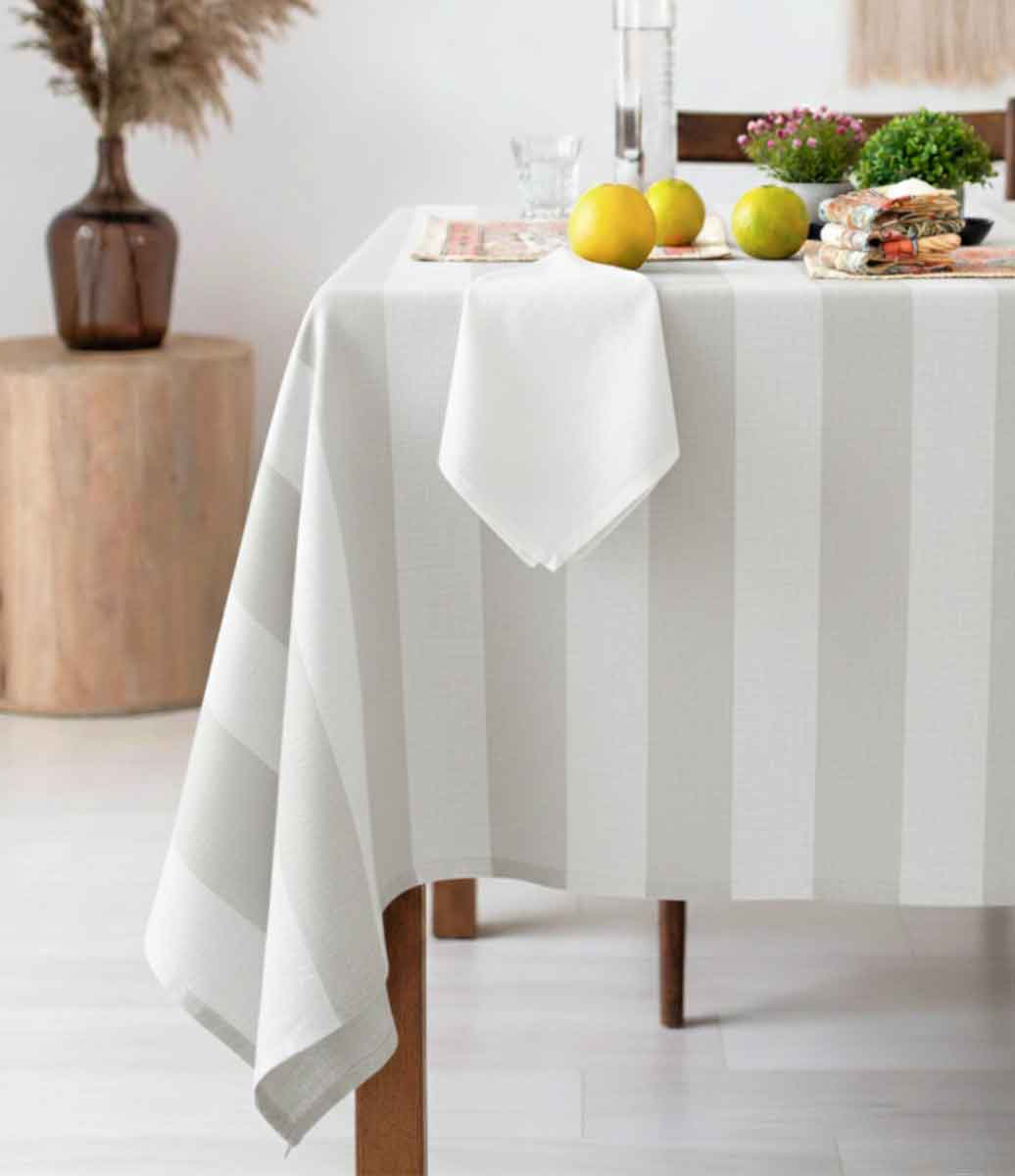ambiente claro com mesa em primeiro plano com toalha de mesa listrada branca