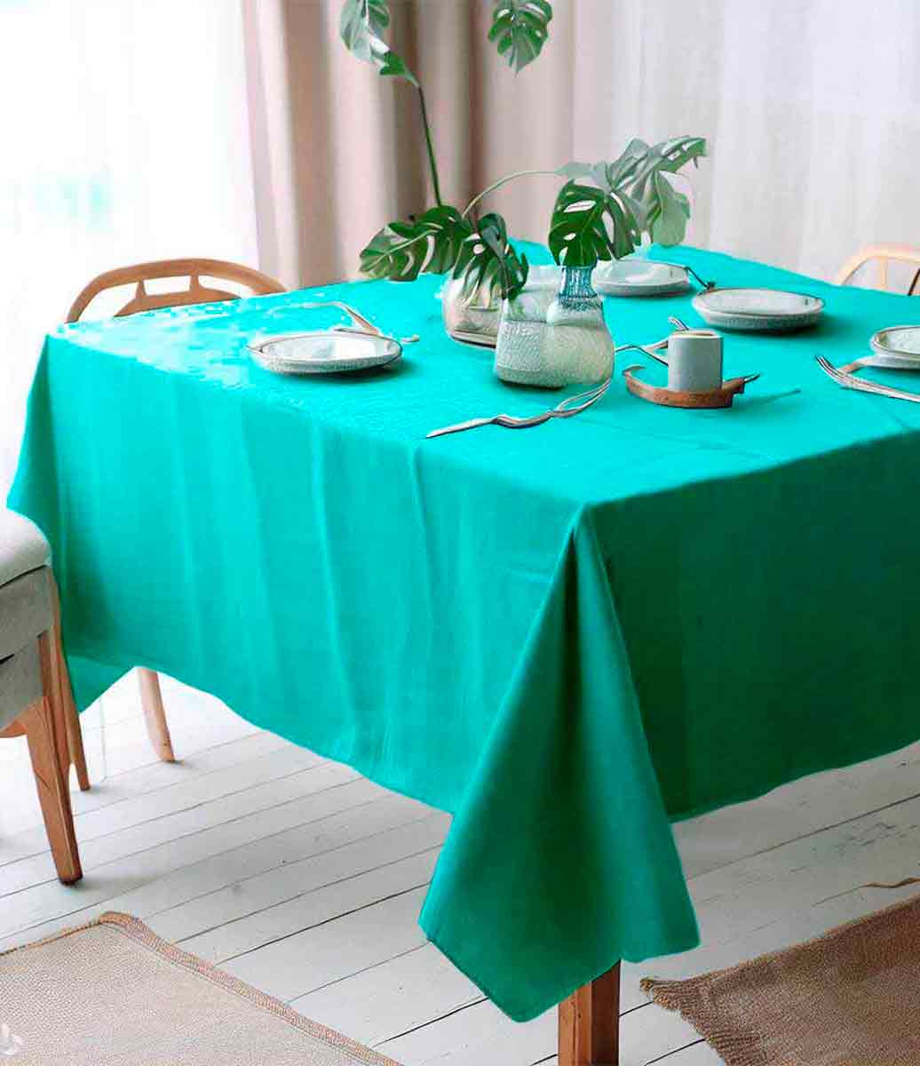 sala de estar com decoração rústica com mesa posta usando toalha de mesa de linho verde claro