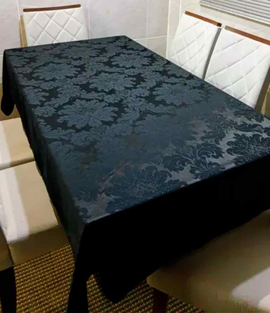 ambiente neutro com cadeiras e mesa decorada com toalha de mesa preta
