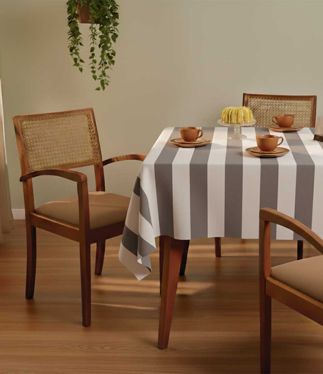 sala de estar aconchegante com plantas, cadeiras de madeira e mesa com xícaras e pires de cerâmica e toalha de mesa listrada branco e cinza