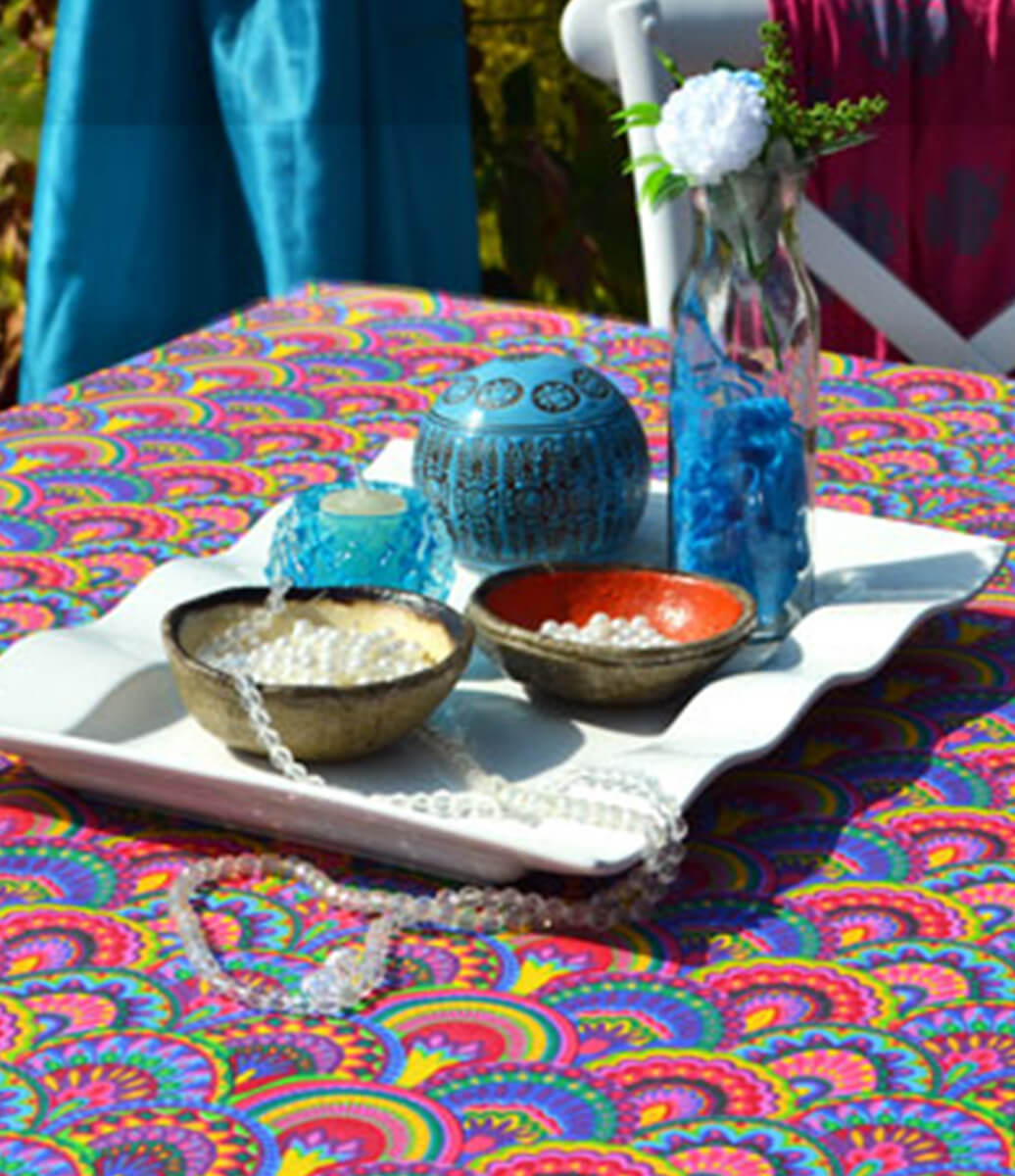 jardim com mesa decorada com toalha de mesa étnica rosa estampada colorida