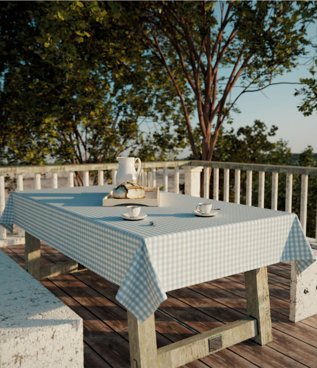 ambiente aberto e rústico com mesa decorada para café da manhã com toalha de mesa azul xadrez retangular
