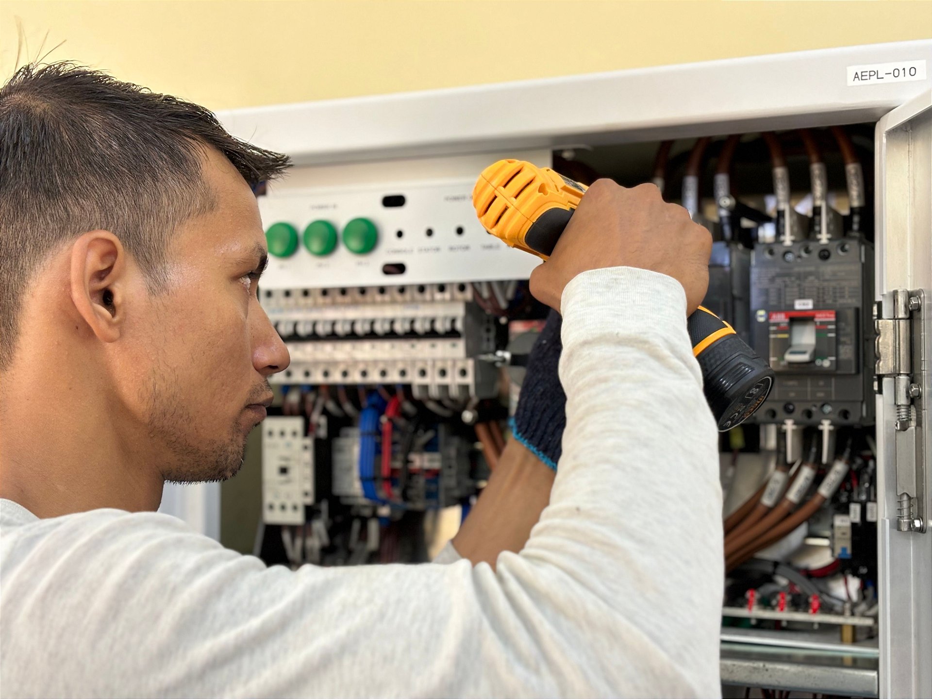 Eletricista trabalhando em quadro elétrico para checklist de materiais