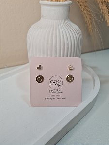 Cartela com brinco de coração e de plaquinha com coração dourados