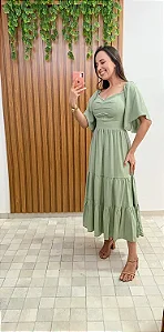 Vestido verde midi com decote coração, drapeado no busto e mangas amplas tipo borboleta. Ele tem a saia em camadas, que dá movimento e leveza ao look.