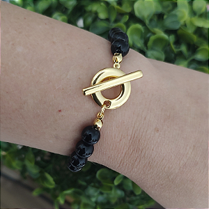 Pulseira com detalhes de resinas pretas ( bolinhas) e fecho T folheado em ouro