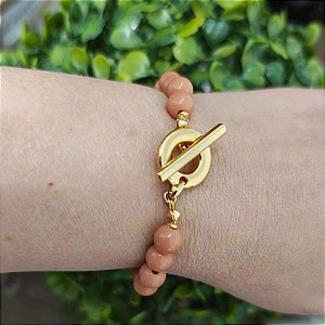 Pulseira com detalhes de resinas bege ( bolinhas) e fecho T folheado em ouro