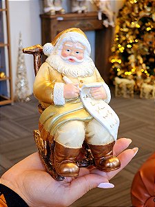PAPAI NOEL COM PRESENTES NA CADEIRA DE BALANÇO DOURADO E BRANCO 15CM - PRÉ VENDA 2025