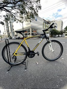 BICICLETA ARO (26) MASCULINA MTB CALOI SUPRA 21 VELOCIDADES (3X7) FREIOS V-BRAKE COR PRETO/AMARELO (USADA)