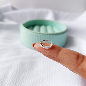 Piercing argolinha cravejada.