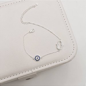 Pulseira entremeios mão vazada e olho grego cravejados