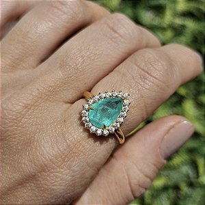 Anel dourado com pedra de zircônia verde e cravejado ao redor com micro zircônias brancas