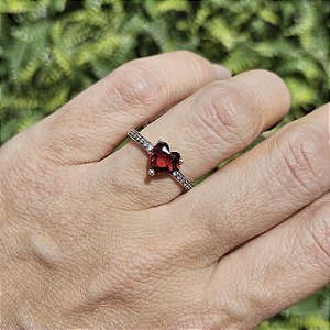 ANEL DE PRATA COM PEDRA DE CORAÇÃO VERMELHA E CRAVEJADO ATÉ A METADE NA LATERAL