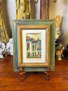 Quadro com moldura em madeira patinada.