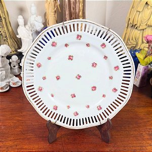 Prato fenestrado em porcelana com filete dourado.