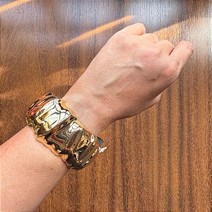 Bracelete Texturizado Dourado: Luxo e Movimento em uma Joia Escultural