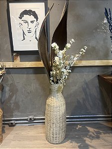 Vaso com galho de coqueiro e flores brancas