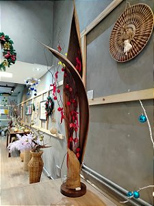 Vaso com galho seco, bolinhas vermelhas e luzes