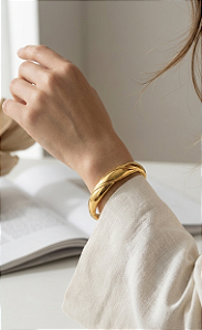 Bracelete Rígido de Aço Banhado a Ouro Abaulado Entrelaçado