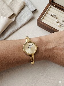 Relógio bracelete dourado fundo dourado