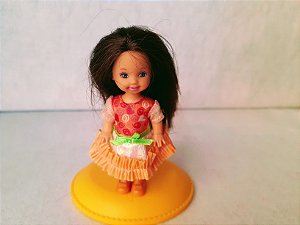 Boneca Kelly morena de cabelo preto , irmã da Barbie, de vestido com fita verde na cintura ,  Mattel.