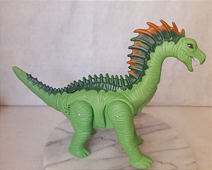 Lucky Dinossauro verde do Dino Valley, anda, emite ruido,acende luz e  a projeta no chão e bota ovo