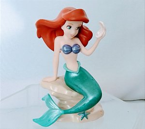 Miniatura Disney acetinada Ariel sentada numa rocha segurando uma concha, usada 7 cm