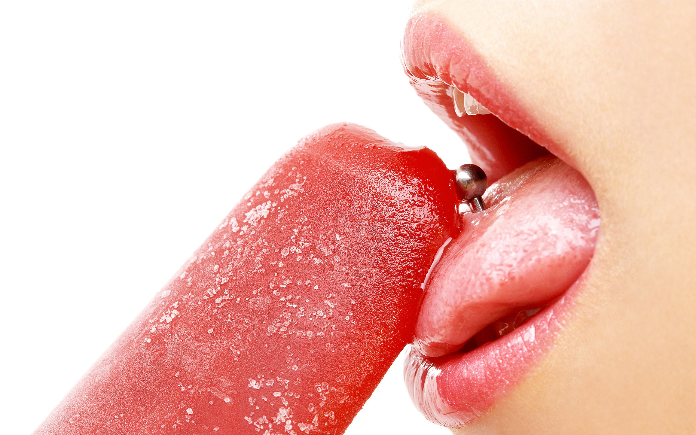 mulher com piercing na língua lambendo sorvete vermelho