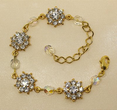 Tornozeleira flor de strass base ouro