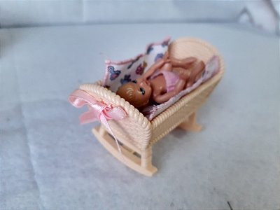 Boneca bebê articulada da Barbie no berço bege de balanço imita vime com fita rosa