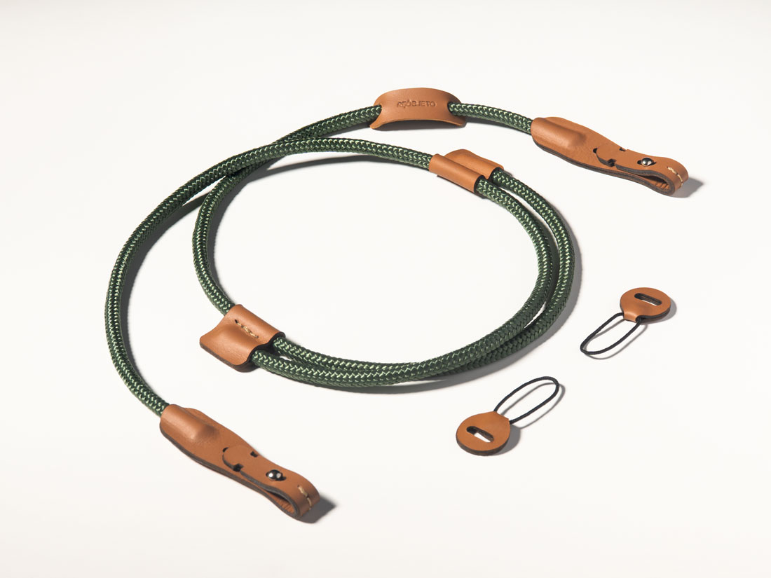 Correia para câmera em couro caramelo e corda de malha sintética verde. Correia para câmera em couro caramelo e corda de malha sintética verde.