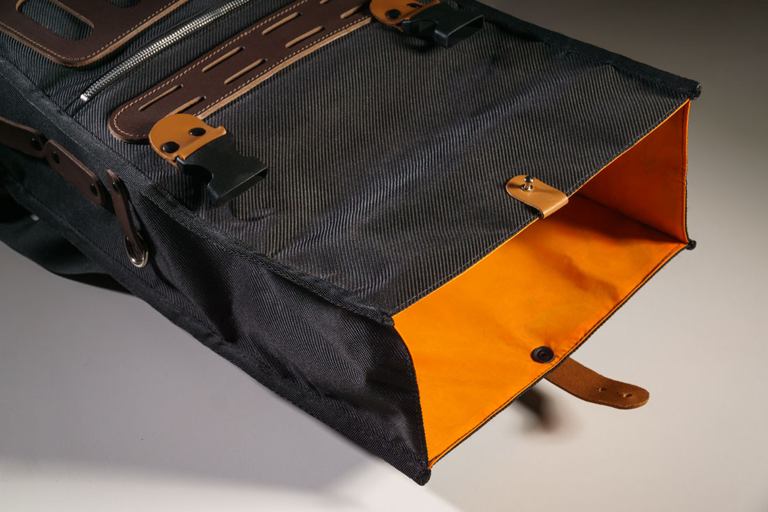 O fechamento é em estilo roll bag, que se abre e aumenta a capacidade de carga do alforje.
