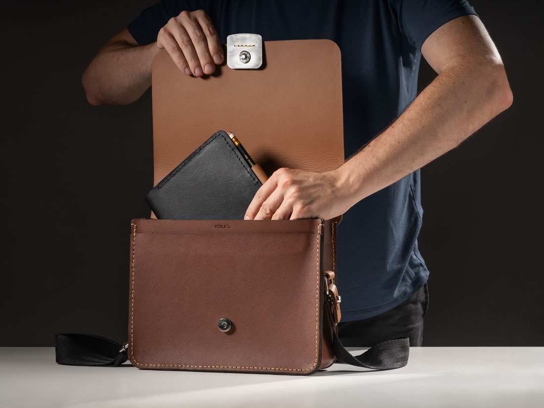 O compartimento interno carrega diversos itens diários. Aqui, carregando nossa Capa para Caderno Bullet Journal A5 (BuJo).