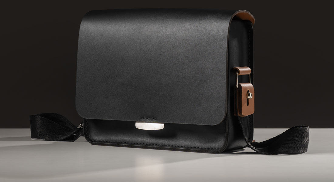 Bolsa Alma em couro bicolor preto e caramelo.