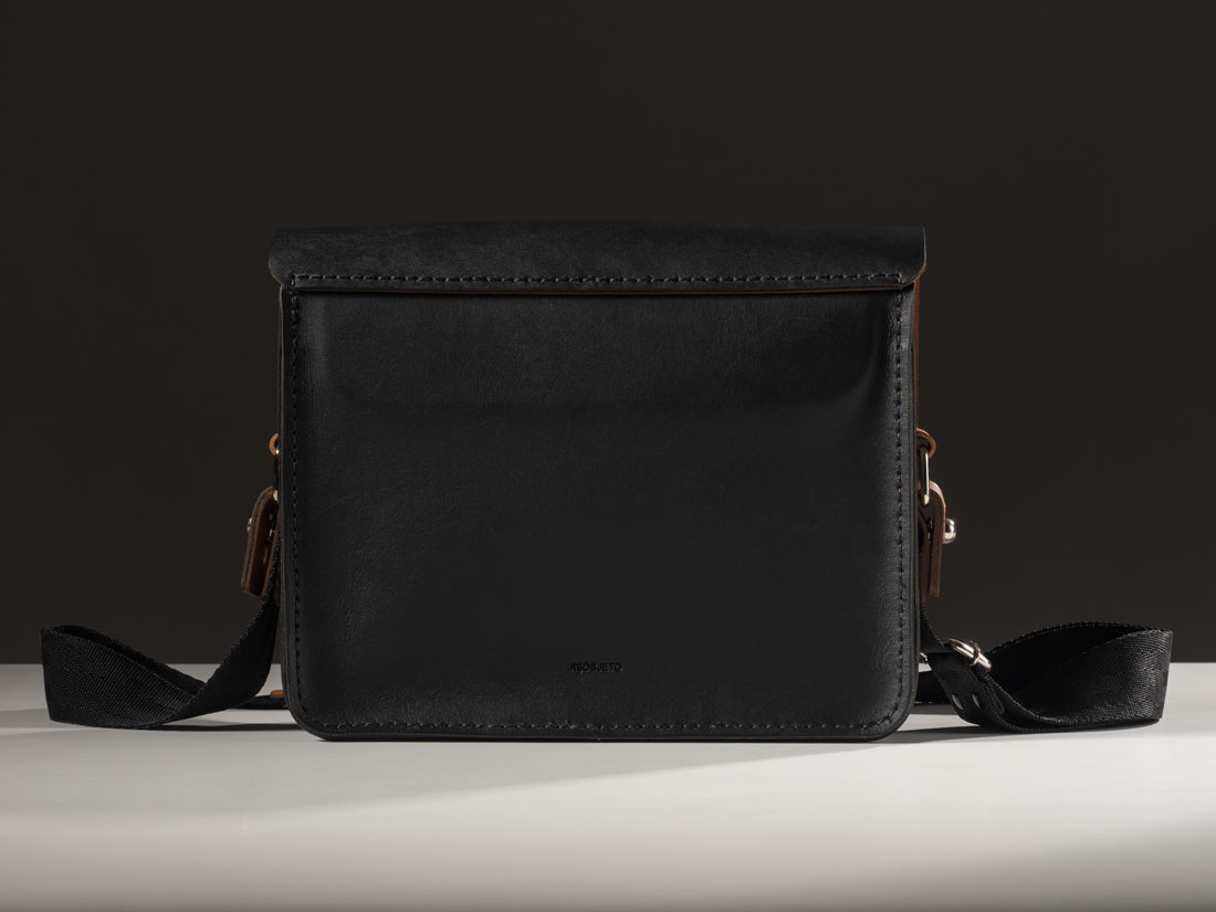 Bolsa Alma em couro bicolor preto e caramelo.