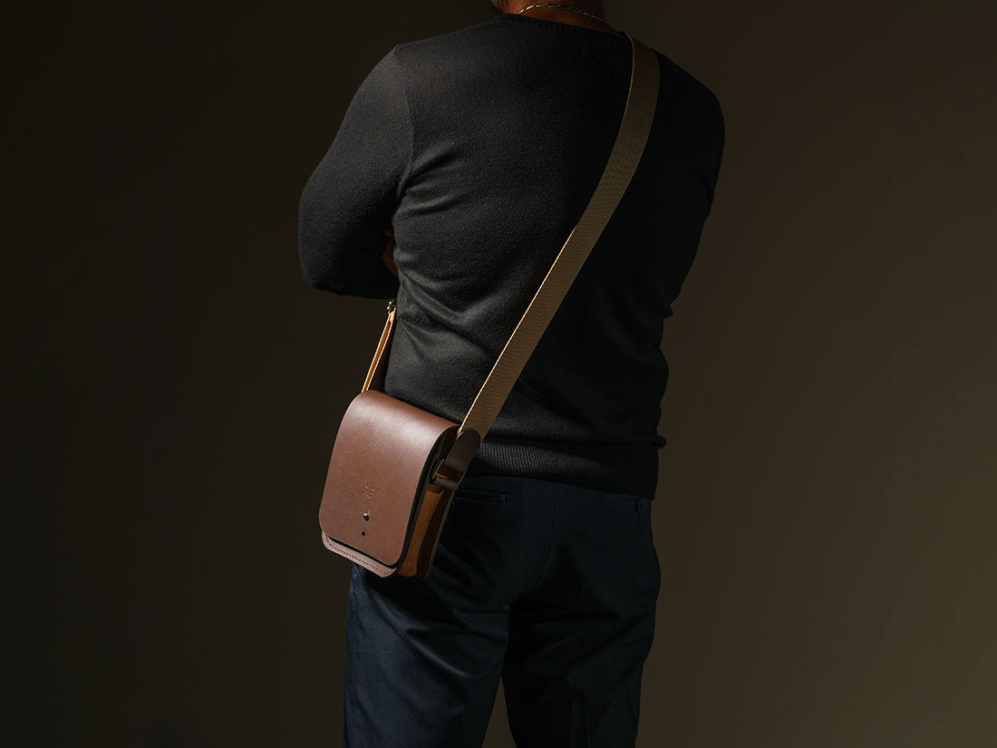 Bolsa Cube em couro bicolor marrom café e caramelo usada a tiracolo como uma shoulder bag.